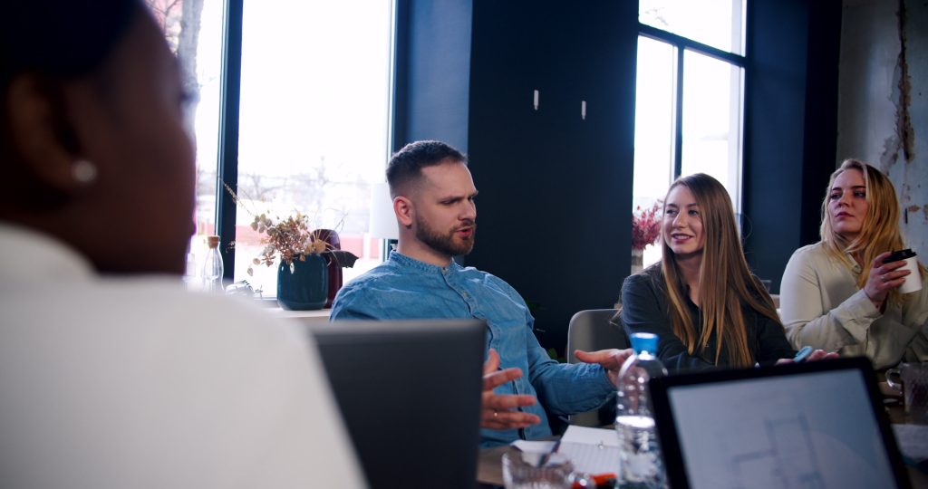 four people talking at their work